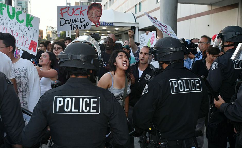 Protesters attacked trump supporters as they left the rally, burned an american flag, Trump paraphernalia and scuffled with police and each other. / AFP / JOSH EDELSON (Photo credit should read JOSH EDELSON/AFP/Getty Images)
